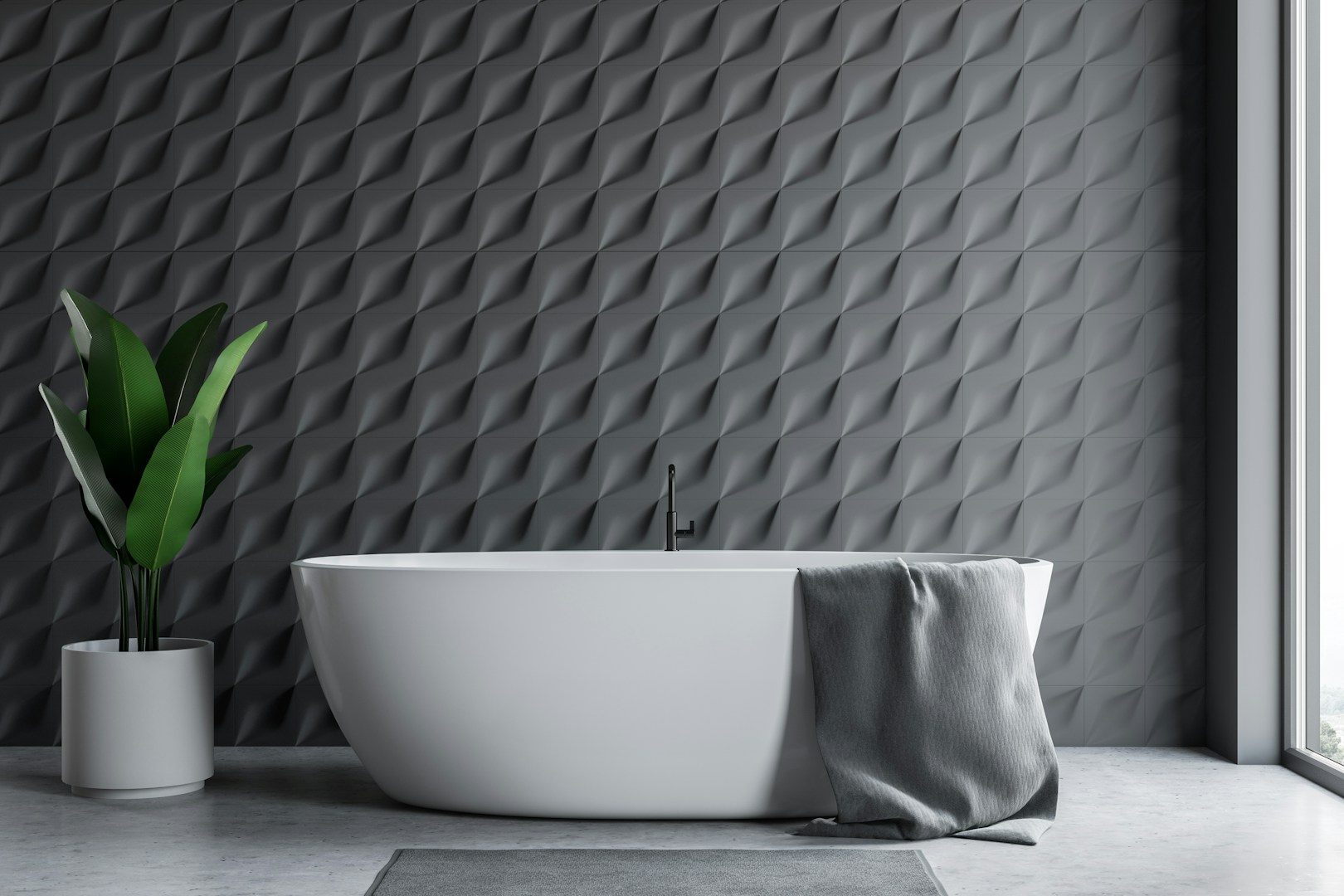 Freistehende weiße Badewanne vor einer dunkelgrauen Fliesenwand mit plastischer Oberfläche